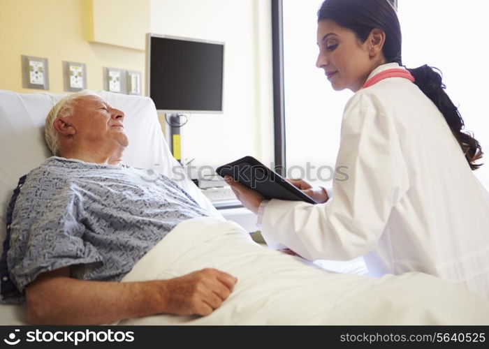 Doctor With Digital Tablet Talking To Patient In Hospital