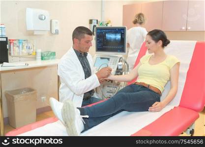 doctor with female patient undergoing arm echography