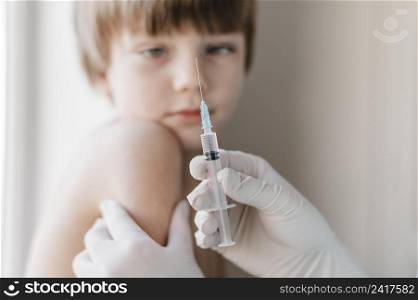 doctor with gloves getting vaccine kid