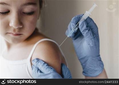 doctor with gloves giving little child vaccine