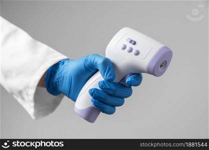 doctor with gloves holding thermometer