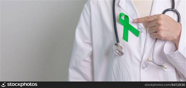 Doctor with green Ribbon for world Mental Health Day, Liver, Gallbladders, bile duct, cervical, kidney Cancer and Lymphoma Awareness month. Healthcare and world cancer day concept