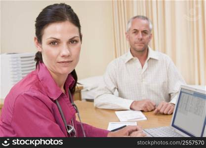 Doctor with laptop and man in doctor&acute;s office frowning