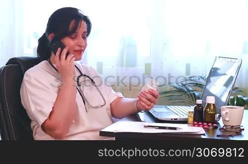 Doctor with laptop computer talking on the phone with patient and giving advice about medicine