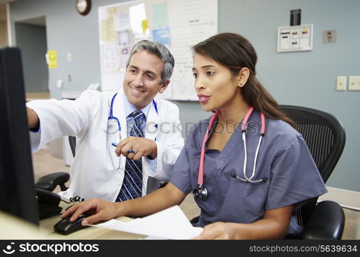 Doctor With Nurse Working At Nurses Station