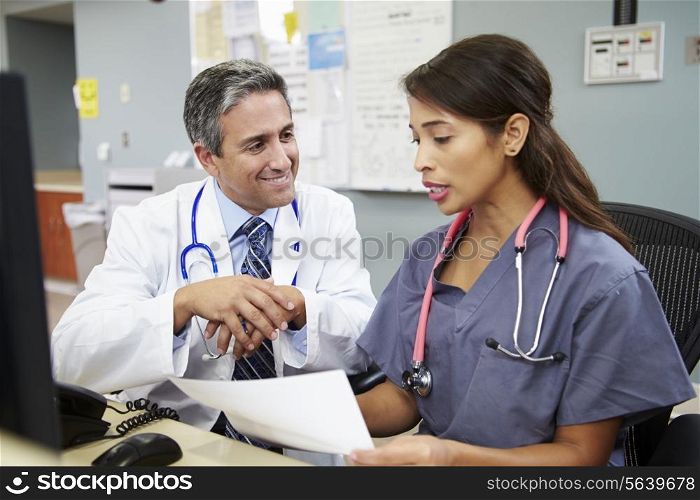 Doctor With Nurse Working At Nurses Station