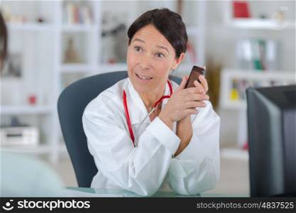 doctor with patient and talking on the phone