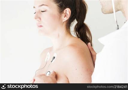 doctor with stethoscope checking respiration lady