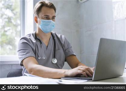doctor with stethoscope medical mask working laptop