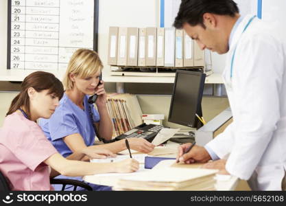 Doctor With Two Nurses Working At Nurses Station