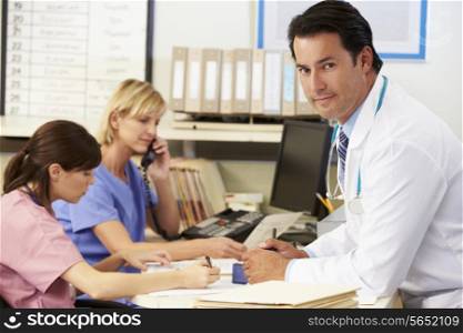 Doctor With Two Nurses Working At Nurses Station