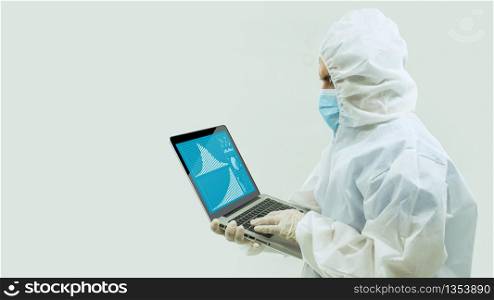 Doctor with white bioprotective suit and blue mask standing holding with his hands an open laptop with statistics on his screen on white background. Doctor with bioprotective suit and blue mask standing holding with his hands an open laptop with statistics on his screen on white background