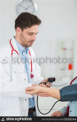 doctor with white coat taking patients blood pressure