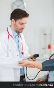 doctor with white coat taking patients blood pressure