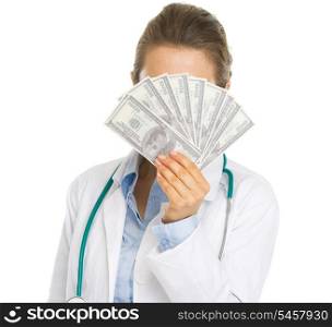 Doctor woman hiding behind fan of dollars