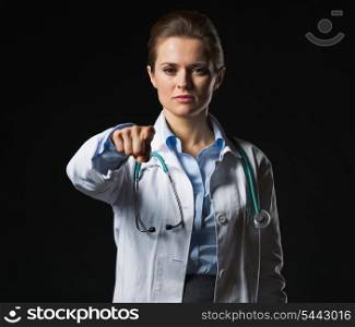 Doctor woman pointing in camera isolated on black