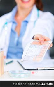 Doctor woman sitting at office table and giving medical prescription. Closeup. &#xA;