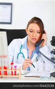 Doctor woman sitting in office and making phone call&#xA;