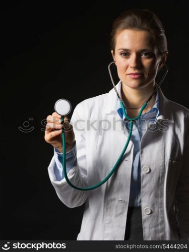 Doctor woman using stethoscope on black background