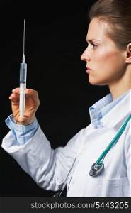 Doctor woman with syringe on black background