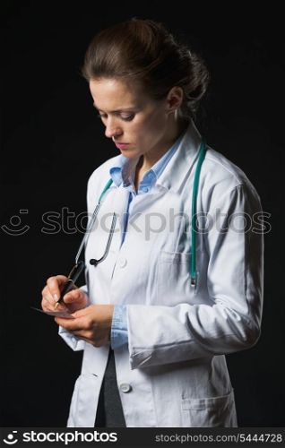 Doctor woman writing prescription isolated on black