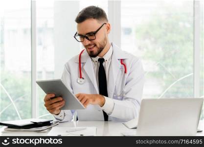 Doctor working on tablet computer at office in the hospital. Medical and healthcare concept.. Doctor working on tablet computer in the hospital.