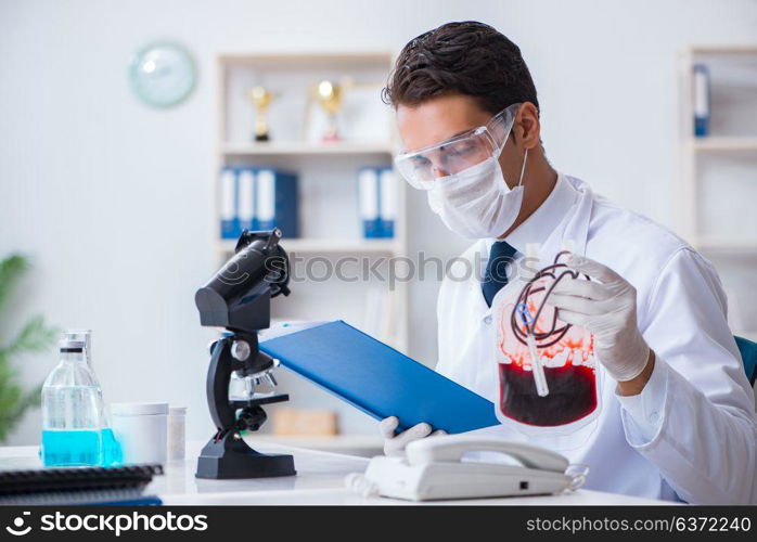Doctor working with blood samples in hospital clinic lab
