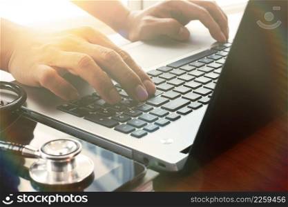 Doctor working with digital tablet and laptop computer in medical workspace office and overcast effect