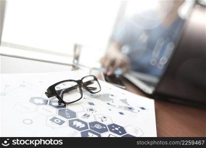 Doctor working with laptop computer and eye glass in medical workspace office and medical network media diagram as concept