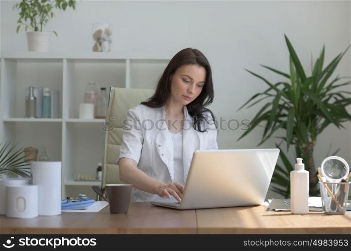 Doctor working with laptop computer at her office