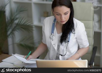 Doctor working with laptop computer at her office