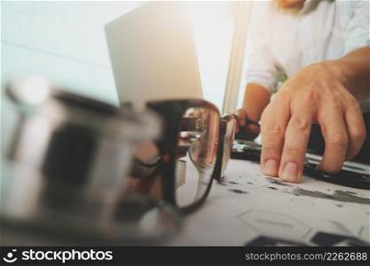 doctor working with laptop computer in medical workspace office and digital medical network media diagram layer with stethoscope and eyeglass foreground as concept