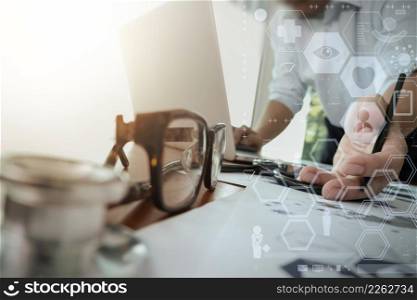 doctor working with laptop computer in medical workspace office and digital medical network media diagram layer with stethoscope and eyeglass foreground as concept