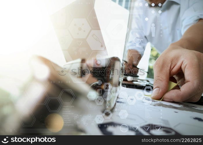 doctor working with laptop computer in medical workspace office and digital medical network media diagram layer with stethoscope and eyeglass foreground as concept