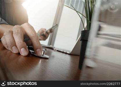 doctor working with laptop computer in medical workspace office and medical network media diagram with green plant and glass of water foreground as concept