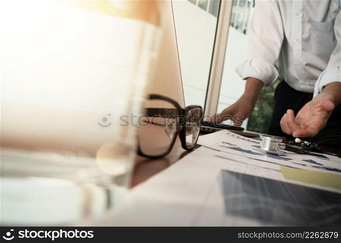 doctor working with laptop computer in medical workspace office and medical network media diagram with glass of water and eyeglass foreground as concept
