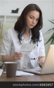 Doctor working with test results and computer at clinic. Filling patient medical record