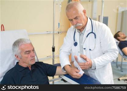 doctor wrapping the hand of the patient