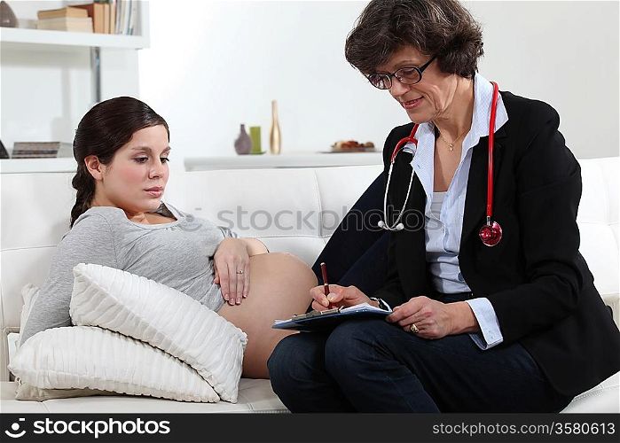 Doctor writing a prescription for a pregnant woman