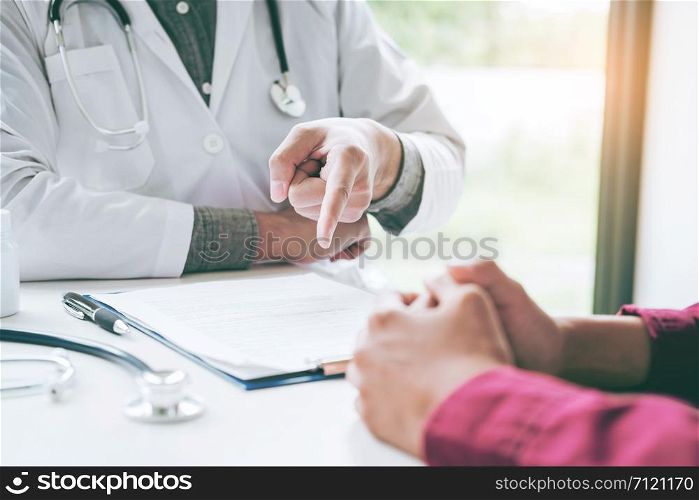 Doctors and patients sit and talk. At the table near the window in the hospital.