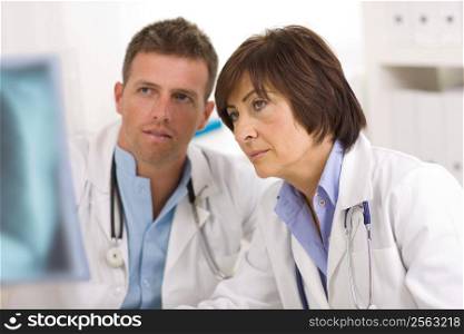 Doctors coworking looking at x-ray image at office.