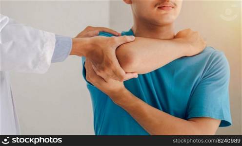 Doctors or physical therapists work to treat the injured arm of a male patient who has performed muscle treatment and pain therapy exercises in the clinic.