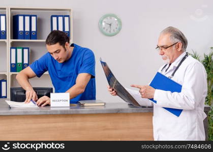 Doctors talking at the reception in hospital. Two doctors talking at the reception in hospital