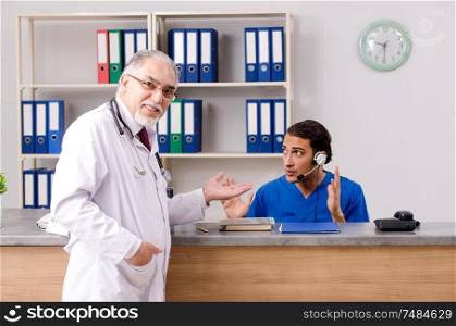 Doctors talking at the reception in hospital. Two doctors talking at the reception in hospital