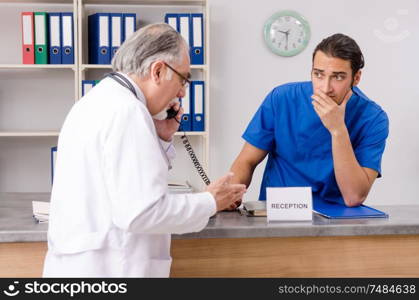 Doctors talking at the reception in hospital. Two doctors talking at the reception in hospital