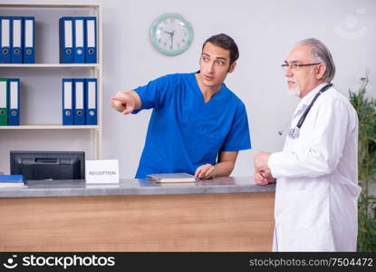 Doctors talking at the reception in hospital. Two doctors talking at the reception in hospital