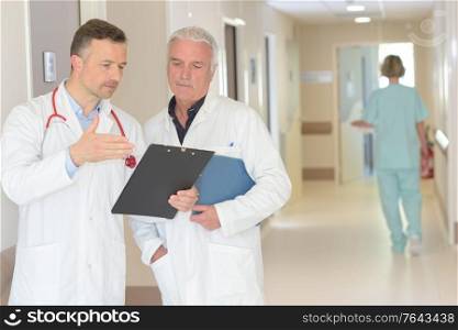 doctors with clipboard at hospital corridor