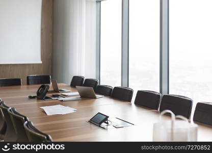 Documents with laptop and telephone on conference table in boardroom at modern office