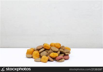 dog food, brown and orange colored kibble against a white background