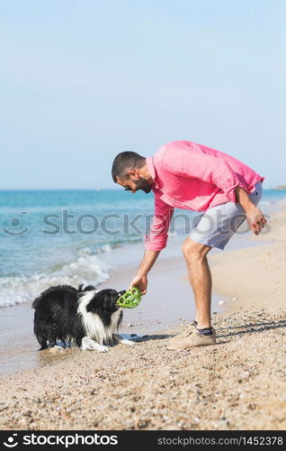 Dog playing with young boy on the beach